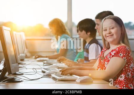 Fille avec le syndrome de Down utilisant l'ordinateur à l'école Banque D'Images