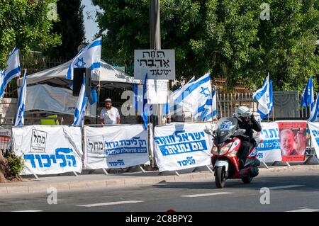 Une poignée de partisans du Likoud se tiennent devant les manifestants anti-corruption, alors qu'une protestation continue contre la corruption proteste contre les crimes présumés de corruption et de mauvaise gestion de l'État par le Premier ministre Benjamin (Bibi) Netanyahou, devant la résidence officielle de Balfour Street, à Jérusalem-Ouest, Israël photographié le 22 juillet 2020. Banque D'Images