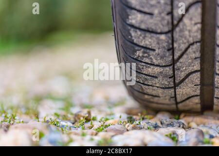 Gros plan de la bande de roulement des pneus de voiture sur la route par temps lumineux Banque D'Images