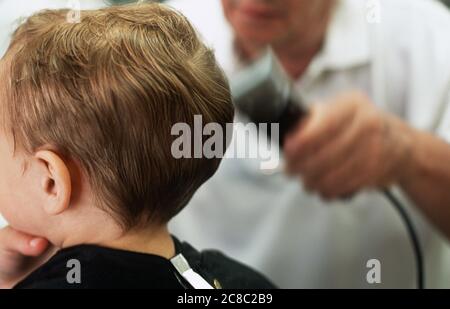 Garçon ayant les cheveux rasés dans les barbiers Banque D'Images