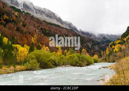 Rivière large avec assez de débit entre les montagnes en automne. Banque D'Images