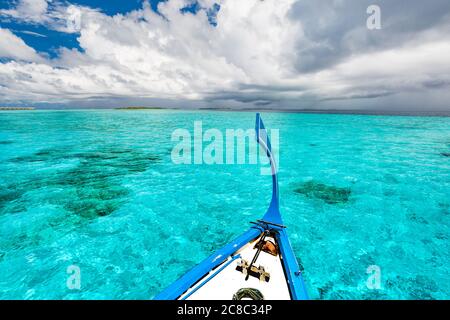 Vue depuis le pont de la bateaux de pêche en bois traditionnel des Maldives sur le paysage de l'île tropicale avec une plage de sable fin et de palmiers Banque D'Images