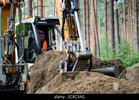 23 juillet 2020, Brandebourg, Grünheide/OT Störitz: Mathieu Barnis de la compagnie Arikon utilise son excavateur pour découvrir l'entrée d'un ancien bunker russe à côté d'un chemin forestier. La construction du bunker est une mesure de compensation pour les interventions dans la nature au sud du site de Tesla. Les chauves-souris doivent hiberner dans le bâtiment souterrain en béton de la prochaine saison froide. Photo: Soeren Stache/dpa-Zentralbild/ZB Banque D'Images