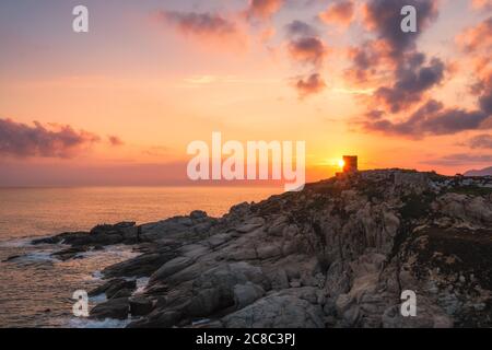 Lever de soleil sur la tour génoise silhouettée à Punta Spano près de Lumio et la côte rocheuse de la région de Balagne en Corse avec le Cap Corse dans le di Banque D'Images