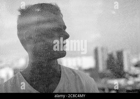 Portrait d'un jeune homme blond contre vue de la ville en double exposition Banque D'Images