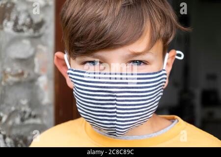 Gros plan portrait d'un garçon 10 enfant portant un masque facial pendant la pandémie du coronavirus de crise Covid 19 en été juillet 2020 Grande-Bretagne KATHY DEWITT Banque D'Images