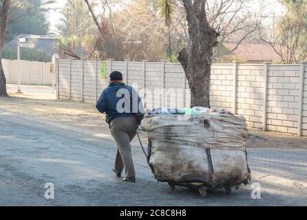 Alberton, Afrique du Sud - une femelle noire non identifiée recueille des objets à recycler pour la revente dans des poubelles de ménage dans un quartier résidentiel Banque D'Images