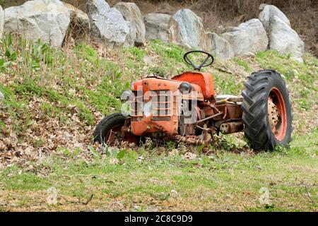 vieux tracteur orange abandonné dans la campagne Banque D'Images