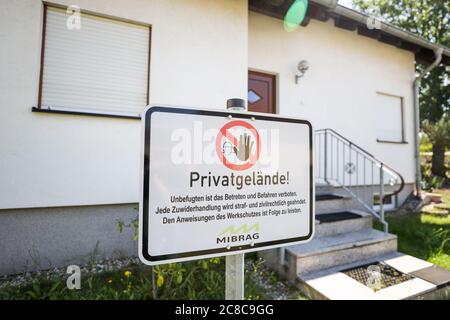 13 juillet 2020, Saxe, Pödelwitz: Un panneau 'propriété privée du Mibrag' se dresse devant une maison familiale abandonnée. La place dans le quartier du charbon brun de Leipzig veut devenir un projet de vitrine du changement structurel. Pödelwitz était en fait censé être dragué, mais se considère sauvé après la sortie du charbon. Une grande partie des habitants ont quitté le village il y a des années, seulement huit des 40 parcelles sont encore habitées. Photo: Jan Woitas/dpa-Zentralbild/ZB Banque D'Images