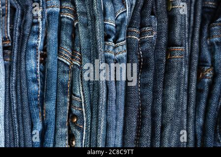 Pile de jeans bleus de différentes nuances. Arrière-plan jeans. Gros plan. Mise au point douce Banque D'Images