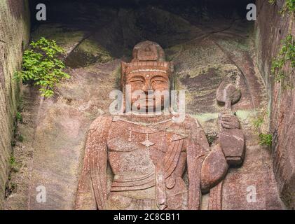 chiba, japon - juillet 18 2020 : gros plan sur l'image de relief géant du bouddha japonais hyaku-shaku kannon sculpté dans la cavité de mur de pierre excavée couverte de wi Banque D'Images