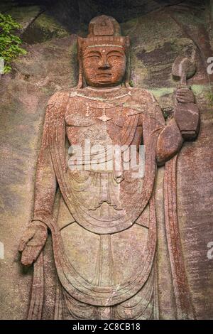 chiba, japon - juillet 18 2020 : gros plan sur l'image de relief géant du bouddha japonais hyaku-shaku kannon sculpté dans la cavité de mur de pierre excavée couverte de wi Banque D'Images