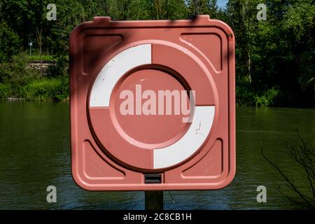 Un écran debout dans lequel il y a une bouée de sauvetage. Il est debout sur la rive d'une rivière. Banque D'Images