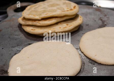 Tortilla au maïs maison nutritive cuites sur une plaque métallique sur un poêle à gaz dans une maison guatémaltèque. Banque D'Images