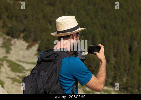 Un jeune homme aime prendre des photos dans la nature sur son chemin au sommet froid de Moncayo, la plus haute montagne du système ibérique, dans le Tarazona regio Banque D'Images