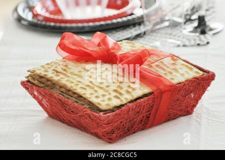 Matzo enveloppé d'un ruban sur une table juive de la Pâque avec des plats en plastique jetables Banque D'Images