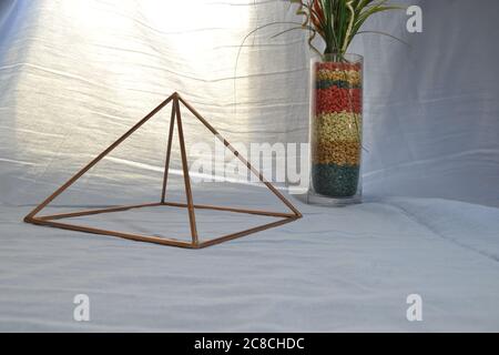 Pyramide de cuivre avec éclairage, avec vase en verre antique et des pierres dans la vue latérale, avec éclairage naturel de fond, pyramide pour usage domestique, Brésil, sud A. Banque D'Images