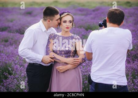 photographe professionnel prend la photo de couple amoureux dans le champ de lavande. histoire d'amour le jour d'été Banque D'Images