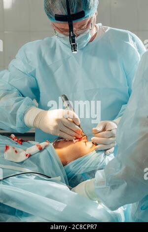 Chirurgien opérant une dose en direct dans la salle de chirurgie Banque D'Images