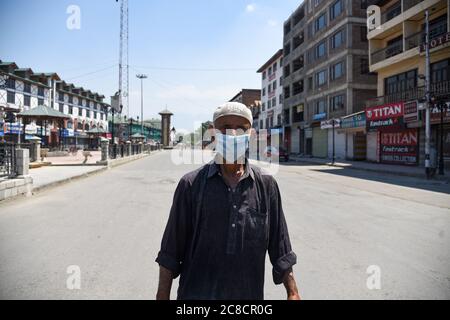 Srinagar, Inde. 23 juillet 2020. Un homme portant un masque marche le long d'une rue déserte pendant les restrictions de verrouillage à Srinagar.des restrictions strictes ont été imposées dans la plupart des parties du Cachemire jeudi, un jour après que l'administration a annoncé un verrouillage complet dans la vallée pour contenir la propagation de COVID-19. Crédit : SOPA Images Limited/Alamy Live News Banque D'Images