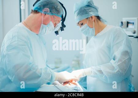 chirurgie, soins de santé, médecine et concept de personnes - groupe de chirurgiens en opération dans la salle d'opération à l'hôpital avec projection de diagramme virtuel Banque D'Images