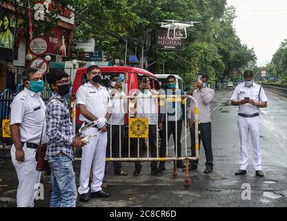 Kolkata, Inde. 23 juillet 2020. Les policiers de Kolkata sont vus à un point de contrôle pour s'enquérir et vérifier les documents des voyageurs sur la route pendant le confinement deux jours par semaine.le gouvernement du Bengale occidental a décidé d'imposer un confinement à la semaine dans l'État pour freiner la montée de la maladie du coronavirus (COVID-19). Seules les personnes qui sont aux services d'urgence et les patients ont l'autorisation de se déplacer ou de se déplacer. Crédit : SOPA Images Limited/Alamy Live News Banque D'Images