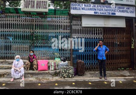 Kolkata, Inde. 23 juillet 2020. Les personnes portant un masque facial sont considérées comme bloquées avec leurs bagages à la gare de Howrah en raison de l'indisponibilité des transports publics pendant le confinement de deux jours par semaine à Kolkata.le gouvernement du Bengale occidental a décidé d'imposer un confinement de semaine dans l'État pour freiner l'augmentation de la maladie du coronavirus (COVID-19). Seules les personnes qui sont aux services d'urgence et les patients ont l'autorisation de se déplacer ou de se déplacer. Crédit : SOPA Images Limited/Alamy Live News Banque D'Images