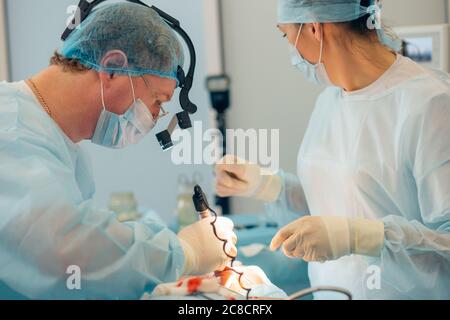 Équipe de chirurgien en uniforme effectuer l'opération sur un patient à la clinique de chirurgie plastique Banque D'Images