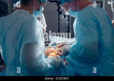 Équipe médicale effectuant l'opération sur le nez. Groupe de chirurgiens au travail en salle d'opération Banque D'Images