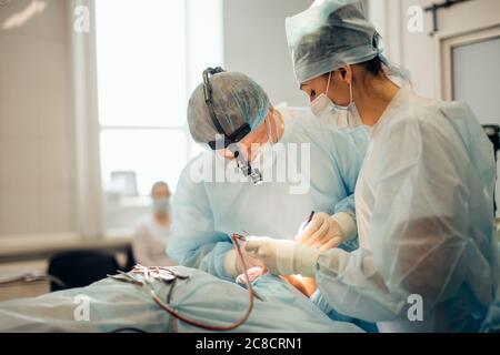 chirurgie, soins de santé, médecine et concept de personnes - groupe de chirurgiens en opération dans la salle d'opération à l'hôpital avec projection de diagramme virtuel Banque D'Images