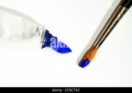 Les artistes peignent un pinceau et un tube de peinture bleue isolés sur un fond blanc Banque D'Images