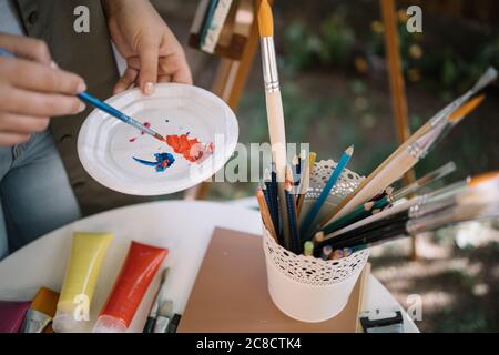 Artiste de culture mélangeant des peintures dans un studio extérieur Banque D'Images