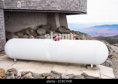 Grand réservoir de propane blanc près d'un bâtiment sur le sommet d'une montagne par un ciel nuageux jour d'automne Banque D'Images