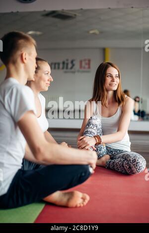 des amis en cours de yoga se déposera au centre de fitness Banque D'Images
