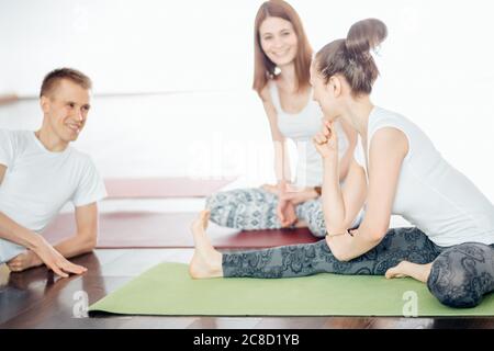 des amis en cours de yoga se déposera au centre de fitness Banque D'Images