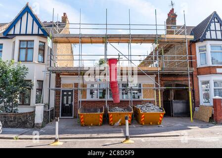 Travaux de construction de bâtiments en cours à Westcliff on Sea, Southend, Essex, Royaume-Uni. Petite pépinière de jour de snapshots. Trois sauts avec chute. Un plein, demi plein, vide Banque D'Images