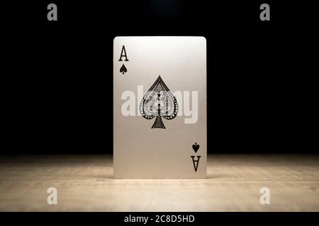 Brecht, Belgique - 29 mai 2020 : un portrait de l'as des pique debout sous les projecteurs sur une table en bois entourée de ténèbres. Il n'y a pas d'autres Banque D'Images