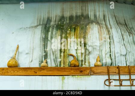 Vieux mur de roche tachée humide avec une véranda décorée de gourdes séchées. Concept artisanal Banque D'Images