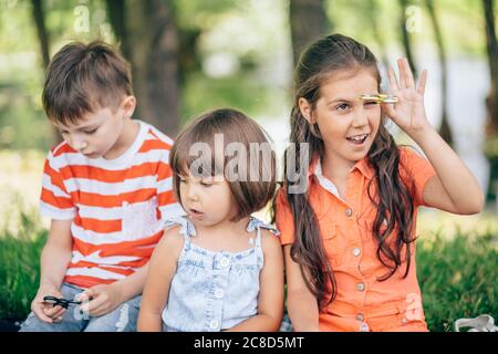 Enfants sur l'herbe souriant et jouant dans le spinner Banque D'Images