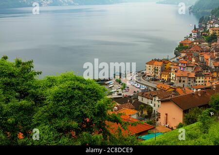 Une vue aérienne d'Argegno, Como une ville sur les contreforts d'une montagne et sur la côte du pittoresque lac de Côme. Toits maisons anciennes colorées, un bateau r Banque D'Images
