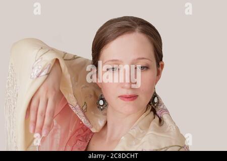 Portrait en gros plan d'une belle jeune femme dansant le flamenco. Sur les épaules il y a un châle beige avec broderie. Les yeux sont à moitié ouverts. Un ha Banque D'Images