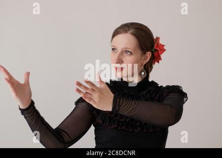 Belle fille dansant le flamenco dans une robe noire. Portrait sur fond blanc. Banque D'Images