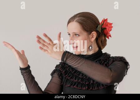 Belle jeune femme dansant le flamenco dans une robe noire. Portrait sur fond blanc. Banque D'Images