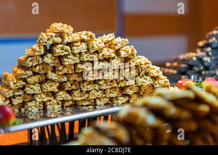 Kozinaki traditionnel dans le désert de l'est sur une plaque métallique en douceur. Bar aux arachides grillées au miel ou au caramel. Des bonbons sains, utiles et savoureux Banque D'Images