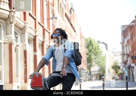 Portrait d'un jeune homme en location de vélo dans la ville, Londres, Royaume-Uni Banque D'Images