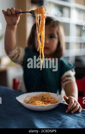 Fourchette de main de petite fille avec spaghetti Banque D'Images