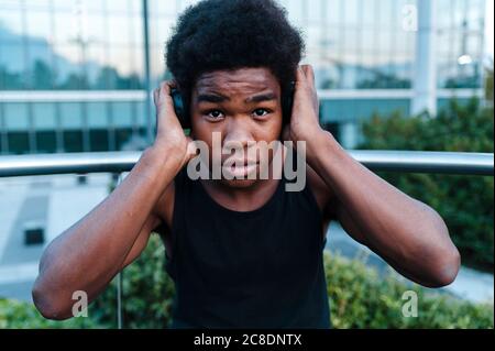 Portrait d'un jeune homme avec un casque qui écoute de la musique la ville Banque D'Images