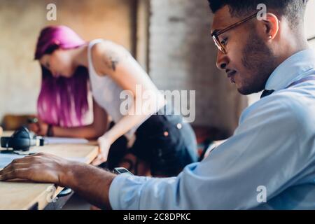 Des gens d'affaires créatifs travaillent à table dans le bureau en mezzanine Banque D'Images