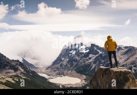 Homme regardant la montagne enneigée contre le ciel nuageux, Patagonie, Argentine Banque D'Images