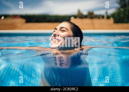 Femme en train de rire à la piscine Banque D'Images
